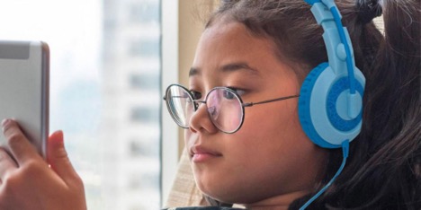 Child with headphones and glasses