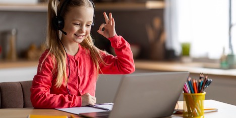 A child wearing headphones and making a hand gesture